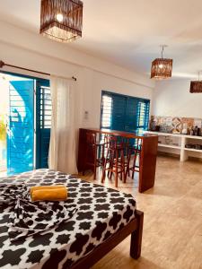 a bedroom with a bed and a kitchen with a table at Casa boa vida in Jericoacoara