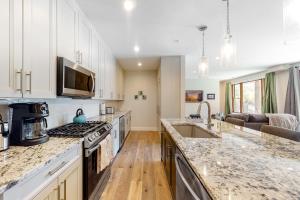 a kitchen with white cabinets and a counter top at Brand New Boardwalk Getaway in Grand Lake