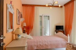 a bedroom with a bed with orange curtains and a window at Eli's home in Kalón Nerón