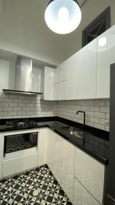 a kitchen with white cabinets and a black and white tile floor at REPUBLICANA CASA HOSTAL - HABITACION 1 QUIMBAYA in Bogotá