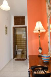 a room with a desk with a lamp and a bathroom at Eli's home in Kalón Nerón +35 photos