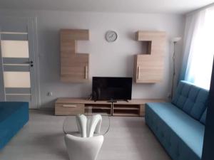 a living room with a blue couch and a tv at Na Spokojnie in Jastarnia