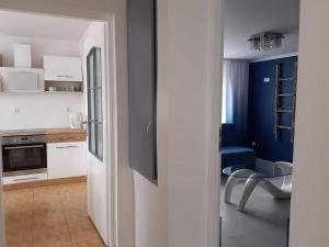 a white kitchen with a table and a blue at Na Spokojnie in Jastarnia