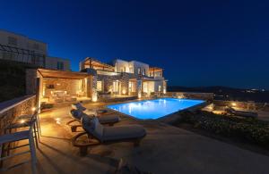 uma villa com piscina à noite em Amallini Suites Mykonos em Praia Super Paradise