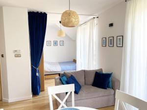 a living room with a couch and a bed at Apartament Kalimera in Żarnowska