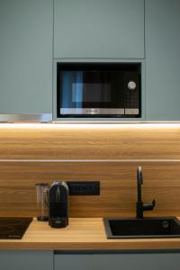 a kitchen counter with a microwave and a sink at CLIC - Comfort Luxury in City of Ioannina in Ioannina