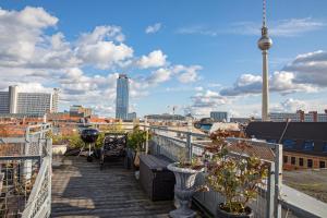 a balcony with potted plants and a view of a city at Alte Schönhauser Penthouse in Berlin