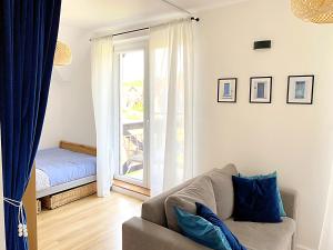 a living room with a couch and a window at Apartament Kalimera in Żarnowska +27 photos