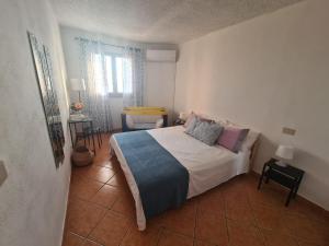 1 dormitorio con 1 cama y 1 silla en Filumare, en Marina di Fuscaldo