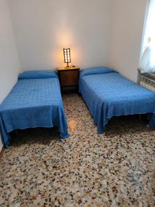 a room with two beds and a table with a lamp at Guado di Pio-appartamento panoramico in Castelpetroso +7 photos