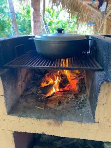 a pot on top of a grill with a fire at Eco Casa Algana La Bambulera in El Limón