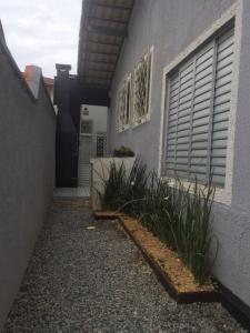 - un bâtiment avec une porte et quelques plantes à côté dans l'établissement Casa Enseada, Prainha, Praia Grande prox mar, à São Francisco do Sul