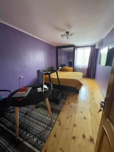 a bedroom with a bed and a desk with a computer at Isolated second floor for rent with separate kitchen and bathroom in Tbilisi City +7 photos