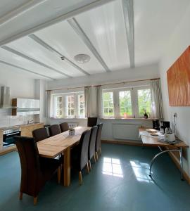 a dining room with a wooden table and chairs at Großes Ferienhaus an der Ostsee "Oldevighus" in Hohenkirchen