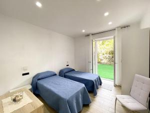 a room with two beds and a table and a window at Maison Marinella in Ischia