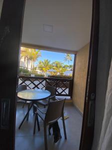a view of a balcony with a table and chairs at Apartamento Enseada Praia do Forte in Praia do Forte