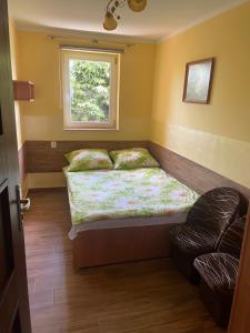 ein kleines Schlafzimmer mit einem Bett und einem Fenster in der Unterkunft Limba in Łeba