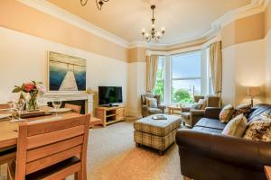 a living room with a couch and a tv at 1 Flaxford House in Grange Over Sands