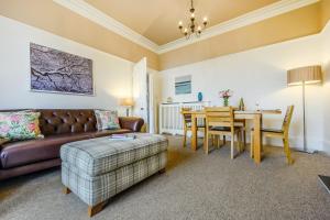 a living room with a couch and a table at 1 Flaxford House in Grange Over Sands