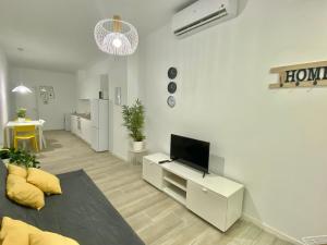 sala de estar con TV en una pared blanca en Mejorana Apartament, en Madrid