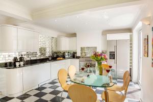 a kitchen with a glass table and chairs at The Art Deco House in Menai Bridge