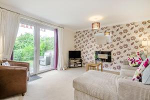 a living room with a bed and a couch and a tv at Kymin View in Monmouth