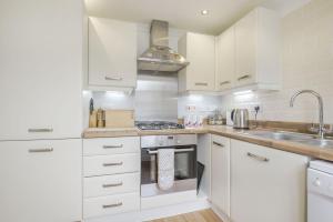 a kitchen with white cabinets and a stove top oven at Kymin View in Monmouth