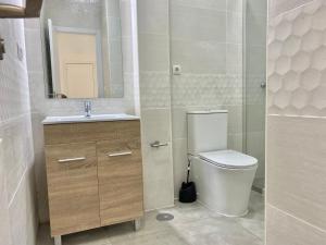 y baño con aseo, lavabo y espejo. en Mejorana Apartament, en Madrid