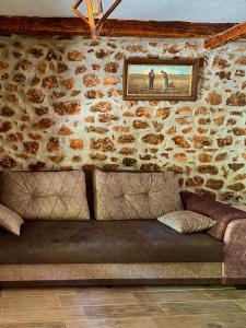 a living room with a couch in a stone wall at Apartment Old House in Podgorica