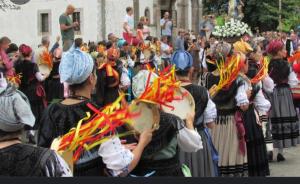 a group of people standing in a crowd in a parade at La Casina de Póo de LLanes in Po
