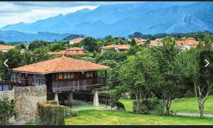a house with a roof on top of a field at La Casina de Póo de LLanes in Po