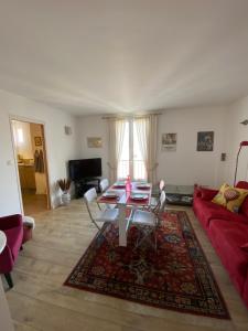 a living room with a table and a red couch at Au cœur de la Vieille Ville in Ajaccio