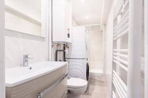 LOFT 1 CHAMBRE PRES MER في نيس: حمام ابيض مع مرحاض ومغسلة