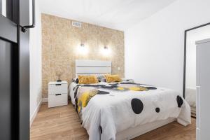 biała sypialnia z dużym łóżkiem z żółtymi poduszkami w obiekcie LOFT 1 CHAMBRE PRES MER w Nicei