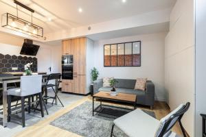 a living room and kitchen with a couch and a table at Loft Magnan - PARKING - idéal couples -BEACH -TRAM & Supermarkets - New & Confort-AC in Nice