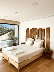 にあるQuinta da Azenhaのベッドルーム1室(大型ベッド1台、木製ヘッドボード付)