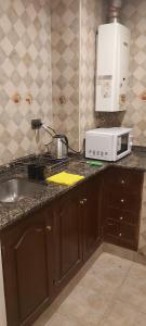 a kitchen counter with a microwave and a sink at depto salta dean funes in Salta