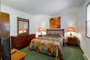 a bedroom with a bed and a dresser and a mirror at Crown Resorts at Wolf Run in DuBois