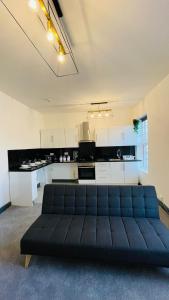 a living room with a couch in front of a kitchen at YO ROOM! Apartments- Next to City Centre Apartment - With Free Parking in Leicester