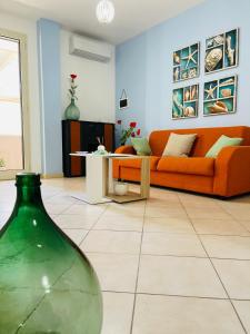 - un salon avec un canapé orange et une table dans l'établissement Nerissa Holiday Home, à Gallipoli