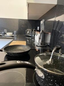a kitchen counter with two pans on a stove at YO ROOM! Apartments- Next to City Centre Apartment - With Free Parking in Leicester