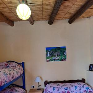 1 dormitorio con litera y lámpara en Hostería el Sol Naciente, en Tilcara