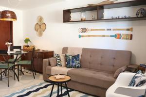 a living room with a couch and a table at Conforto e lazer com vista para o mar - Praia das Dunas Beach House in Cabo Frio
