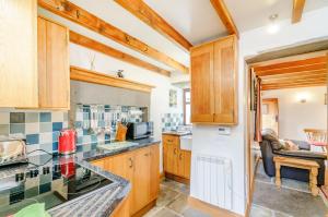 uma cozinha com armários de madeira e uma bancada em Mill Cottage em Hawes