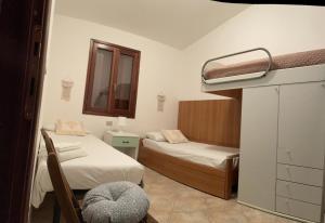 a small room with two beds and a mirror at Via Genova 1480 in San Teodoro