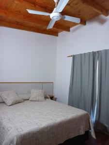 a bedroom with a bed with a ceiling fan at Chalets de la paix in Santa Rosa de Calamuchita +110 photos