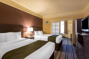 Säng eller sängar i ett rum på Ramada Suites by Wyndham San Diego
