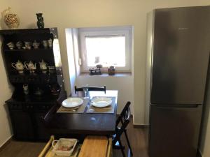 a kitchen with a table and a refrigerator at SzC Lovasbirtok in Lipótmajor