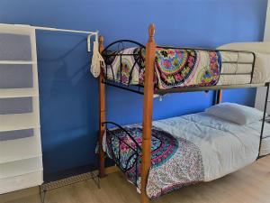 Litera en habitación con pared azul en AtelierSurf29 Guest House, en Almada