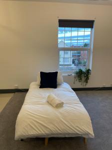 a large bed in a room with a window at YO ROOM! Apartments- Next to City Centre Apartment - With Free Parking in Leicester